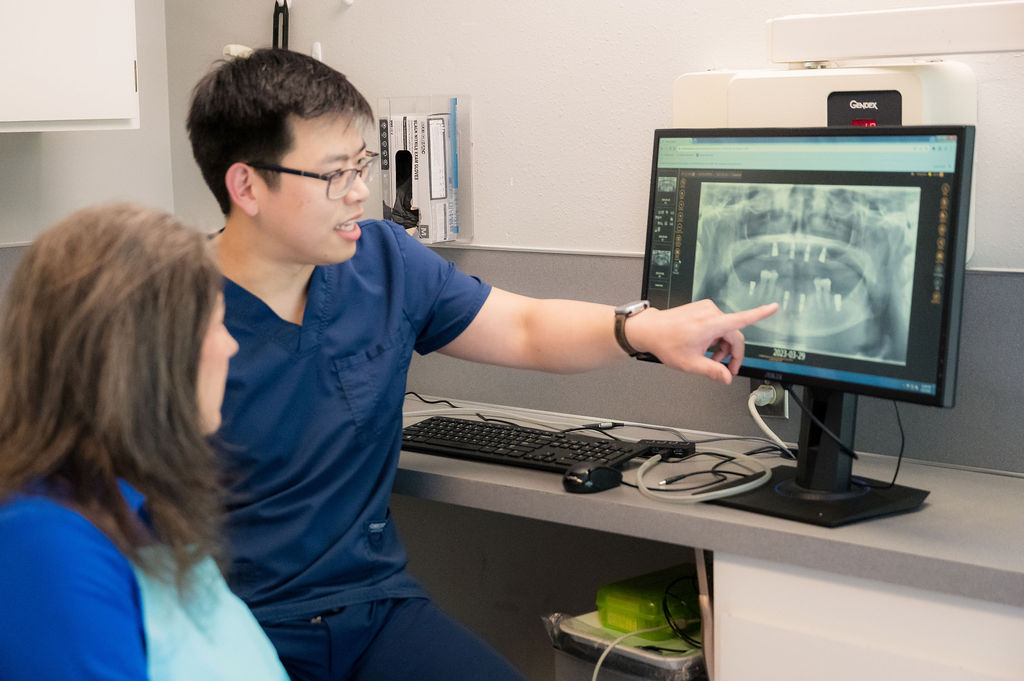 Blog 62 Dr. Xu is explaining dental X-ray results to a patient at Precision Dentistry of Olympia in Olympia, WA